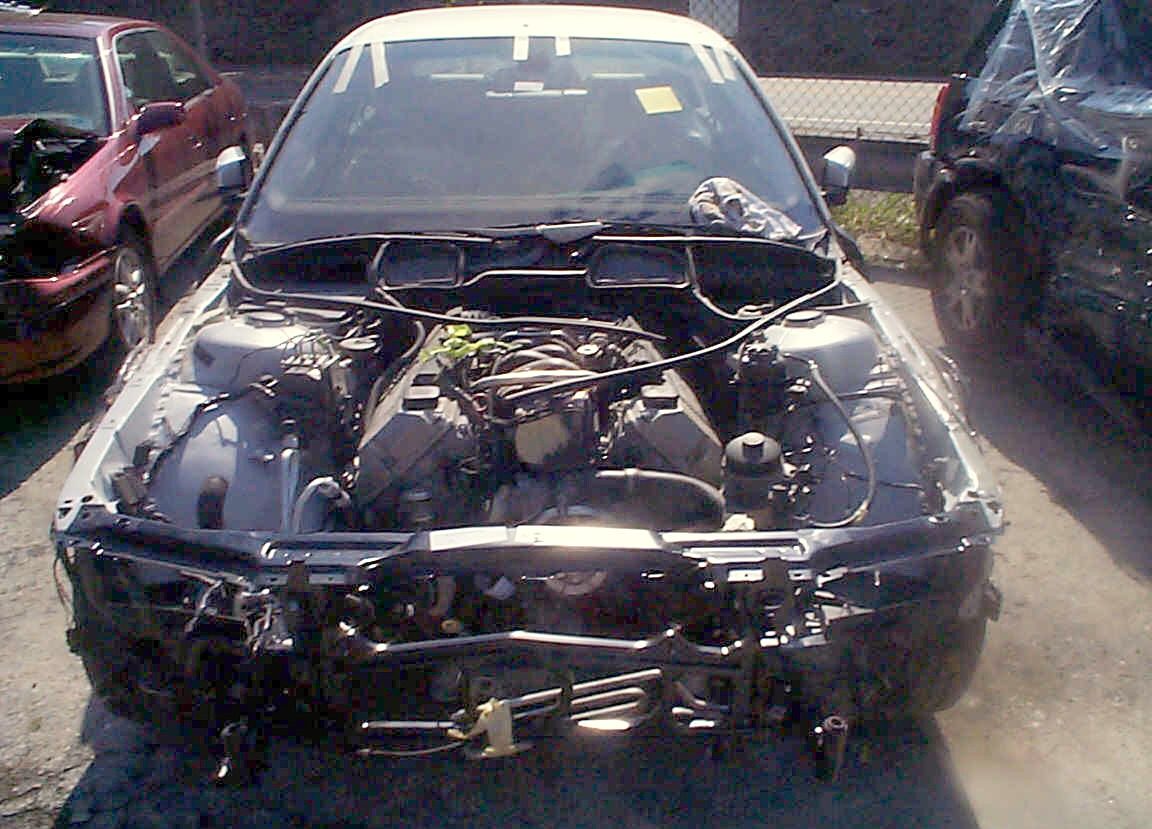 A BMW with its bumper, lights and grille removed during teardown